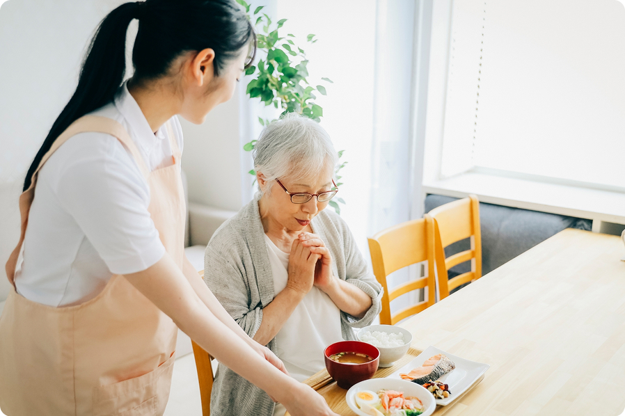 介護スタッフが高齢者に食事を提供している